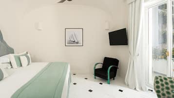Un dormitorio con una cama, una silla, un televisor y una ventana con cortinas.