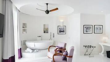 Un bagno moderno con una vasca freestanding, un mobile vanitario con specchio e una ventola a soffitto.
