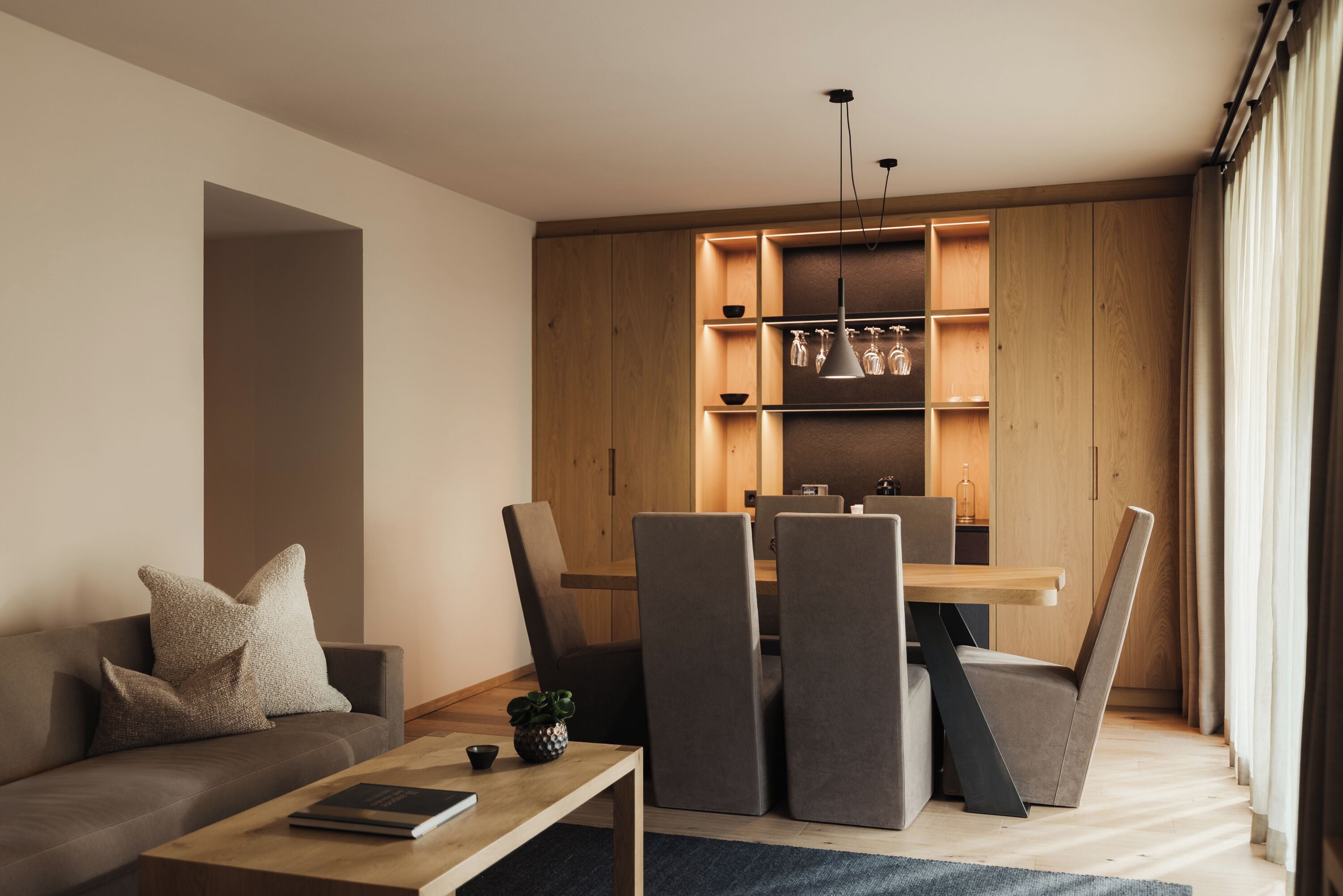 Ein modernes Wohnzimmer mit einer Couch, einem Couchtisch und einem Essbereich mit Stühlen und einem Tisch.