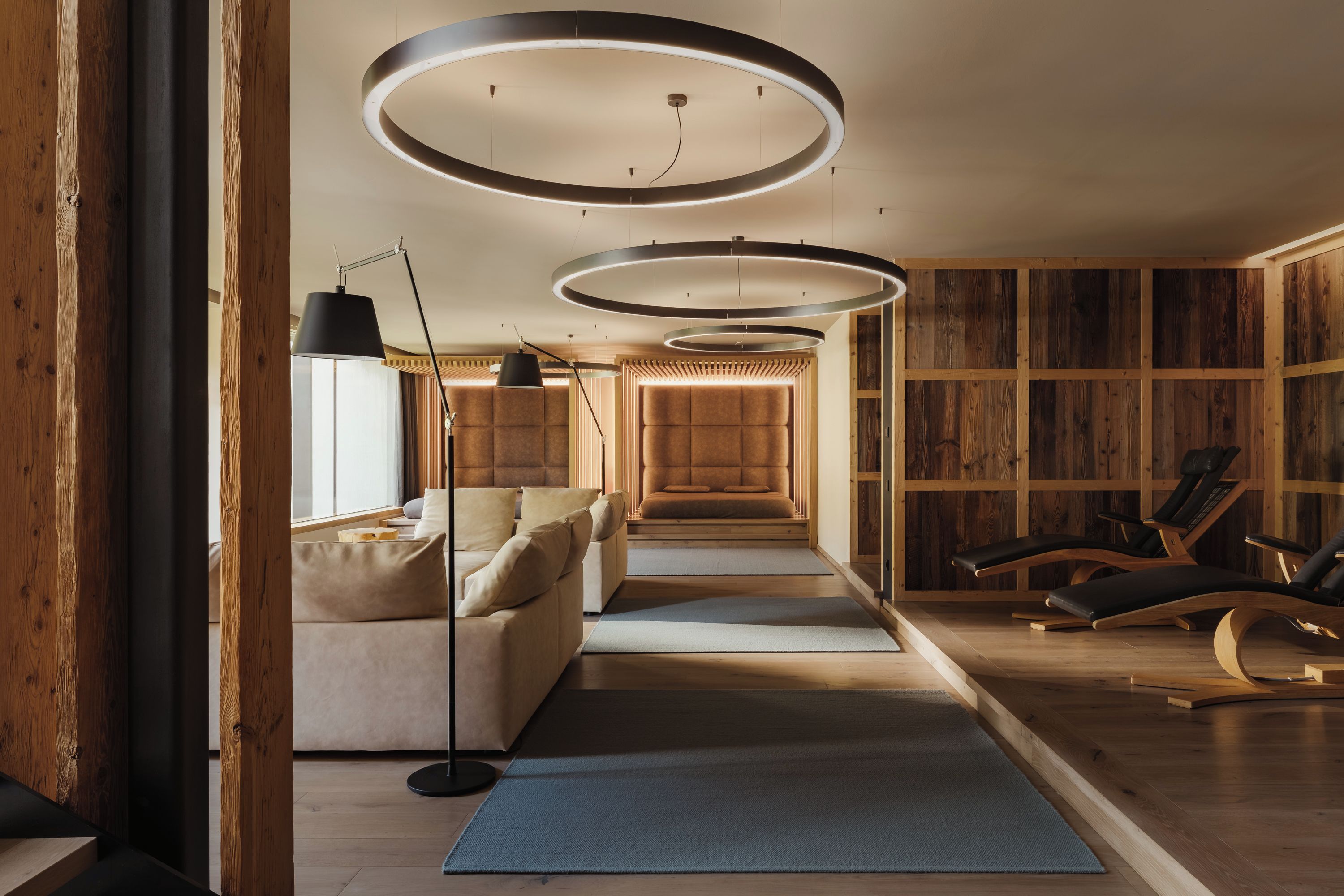 A modern interior with a sofa, a reading lamp, and a wooden wall.