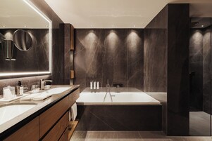 Un baño moderno con un espejo grande, dos lavamanos, una bañera y un mueble de tocador con un gabinete de madera.