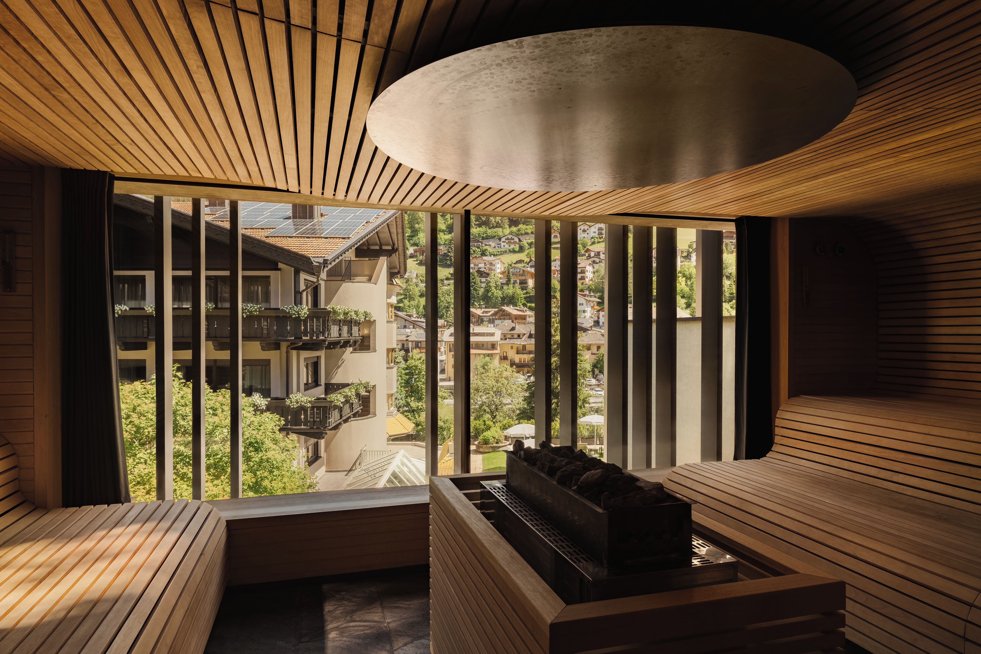 A modern interior with a wooden ceiling, a built-in fireplace, and a view of a residential area.