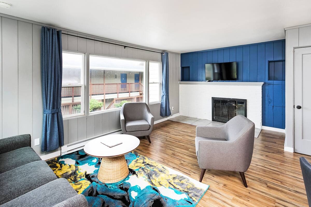 Un salon moderne avec une cheminée, un téléviseur et un balcon offrant une belle vue.