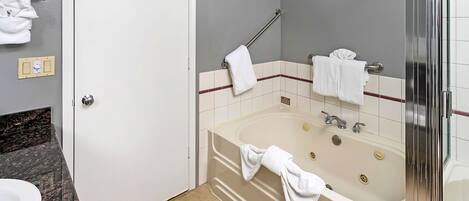 A bathroom with a bathtub, a shower, and a sink.
