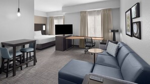 A hotel room with a bed, a desk, a TV, a sofa, and a coffee table. - Residence Inn by Marriott Tampa Oldsmar (Oldsmar)