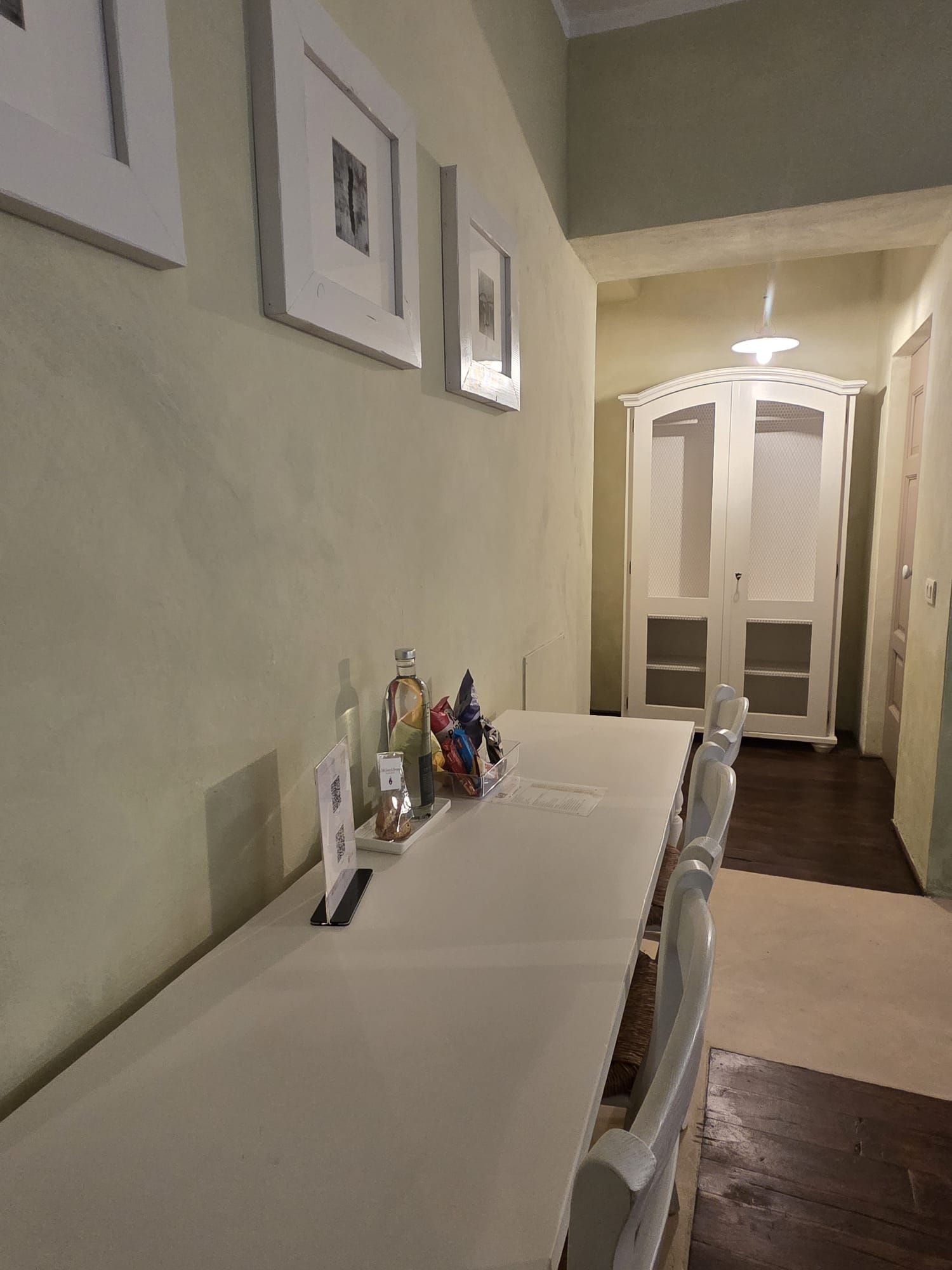 Ein langer Konferenztisch mit Stühlen, einer Whiteboard-Tafel und einer Tür mit einem Netzgitter.
