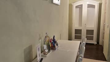 Ein langer Konferenztisch mit Stühlen, einer Whiteboard-Tafel und einer Tür mit einem Netzgitter.
