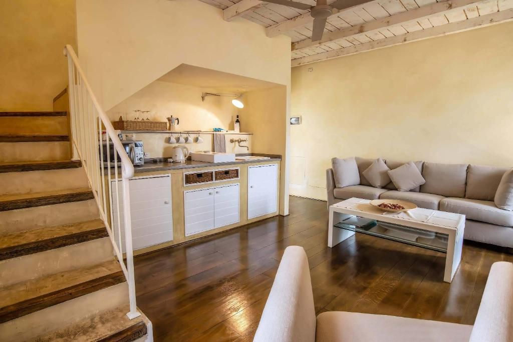 Ein modernes Interieur mit einer Treppe, einer Küchenzeile und einem Wohnbereich inklusive Sofa und Couchtisch.