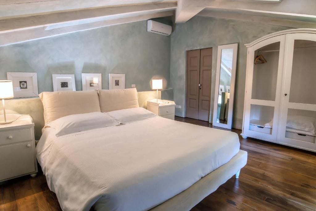 A bedroom with a large bed, bedside tables, a wardrobe, and framed pictures on the wall.
