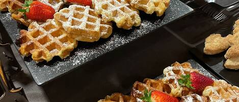 A tray of waffles with strawberries and powdered sugar.