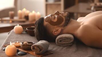 Une personne allongée sur une table de massage, avec des bougies et une serviette à proximité.