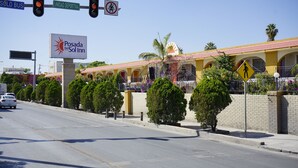 A hotel with a sign reading "Posada Del Sol Inn" and a pedestrian crossing sign. - Hotel Posada del Sol Inn (Torreón)