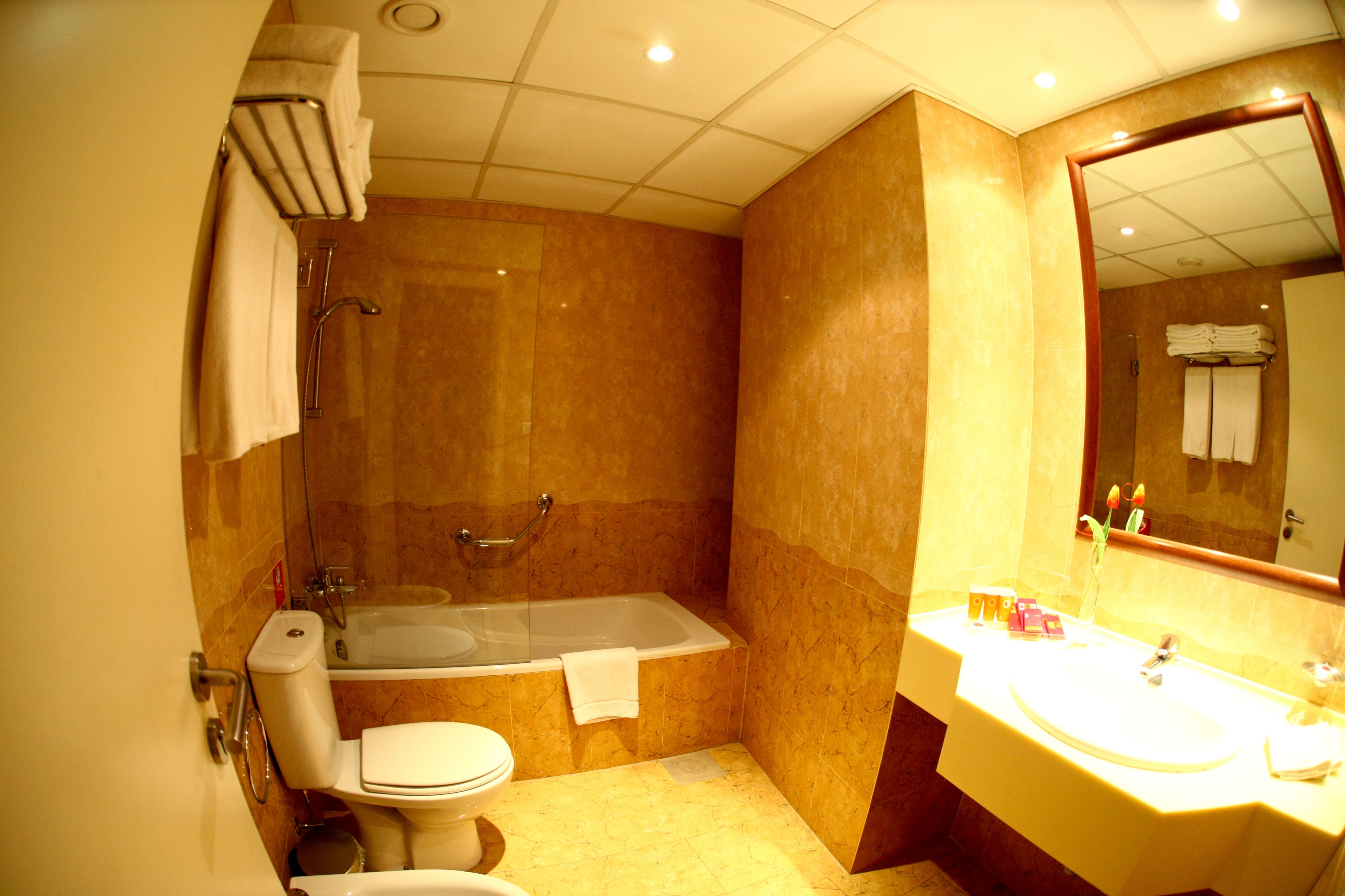 Un baño con bañera, inodoro y lavamanos.