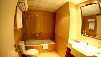 Un baño con bañera, inodoro y lavamanos.