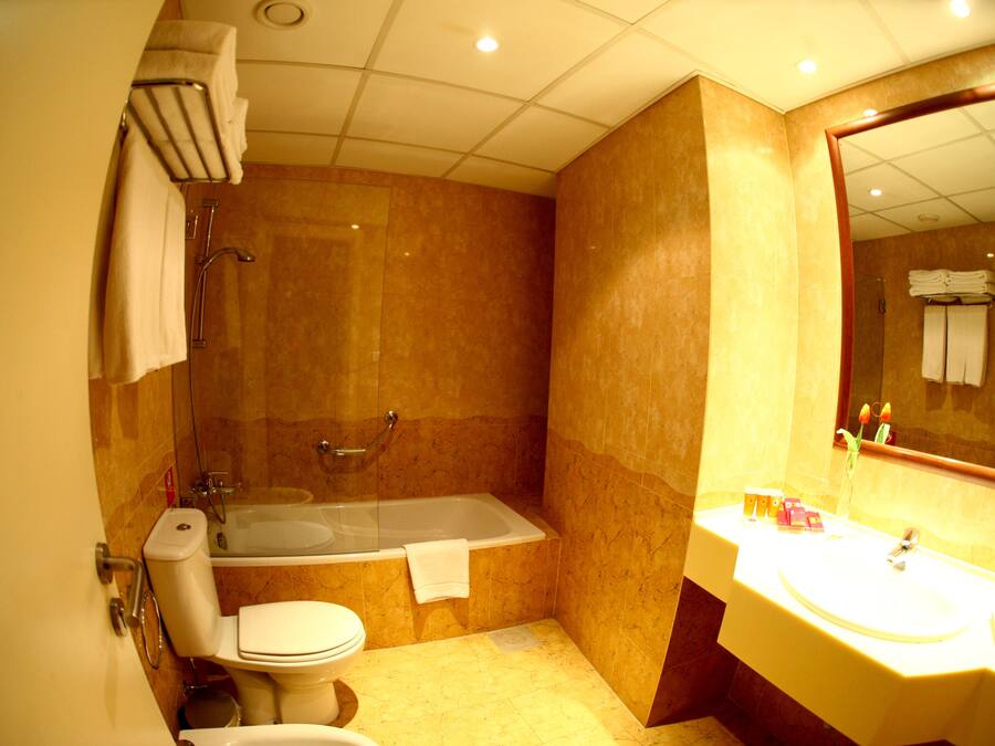 Un baño con bañera, inodoro y lavamanos.