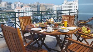 A balcony with a table set for breakfast, overlooking a cityscape. - Markazia Suites (Beirut)