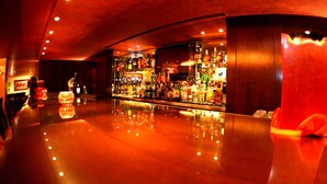 A bar area with a polished floor and a variety of bottles and glasses. - Markazia Suites (Beirut)