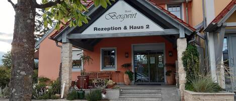 Entrada de hotel con un cartel que dice "Hotel Bergwirt Rezeption & Haus 2".