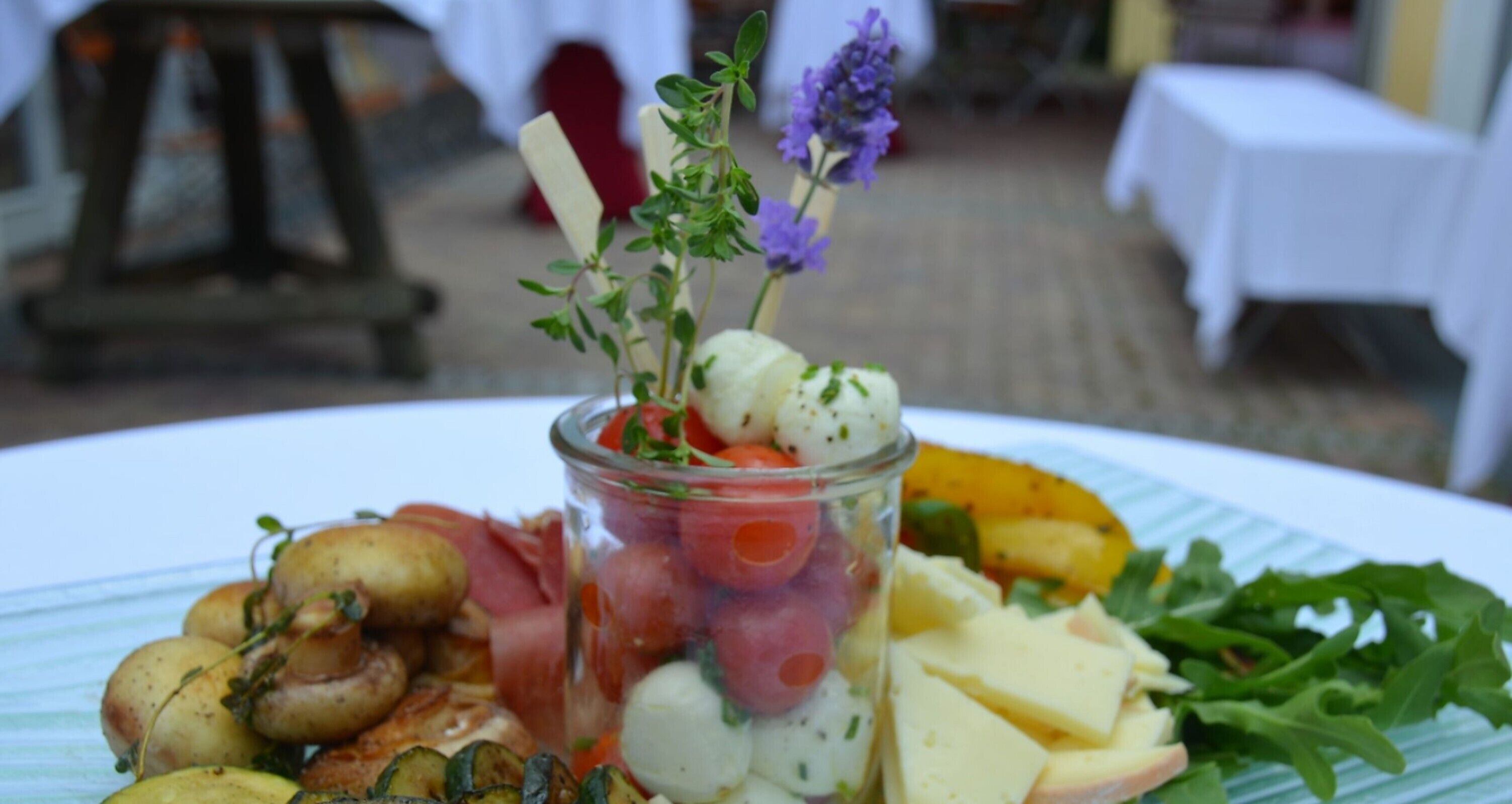 Een bord met diverse soorten eten, zoals paddenstoelen, tomaten, kaas en groenten.