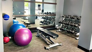 A gym with exercise equipment, including a bench, dumbbells, and exercise balls. - Courtyard by Marriott Albany (Albany)