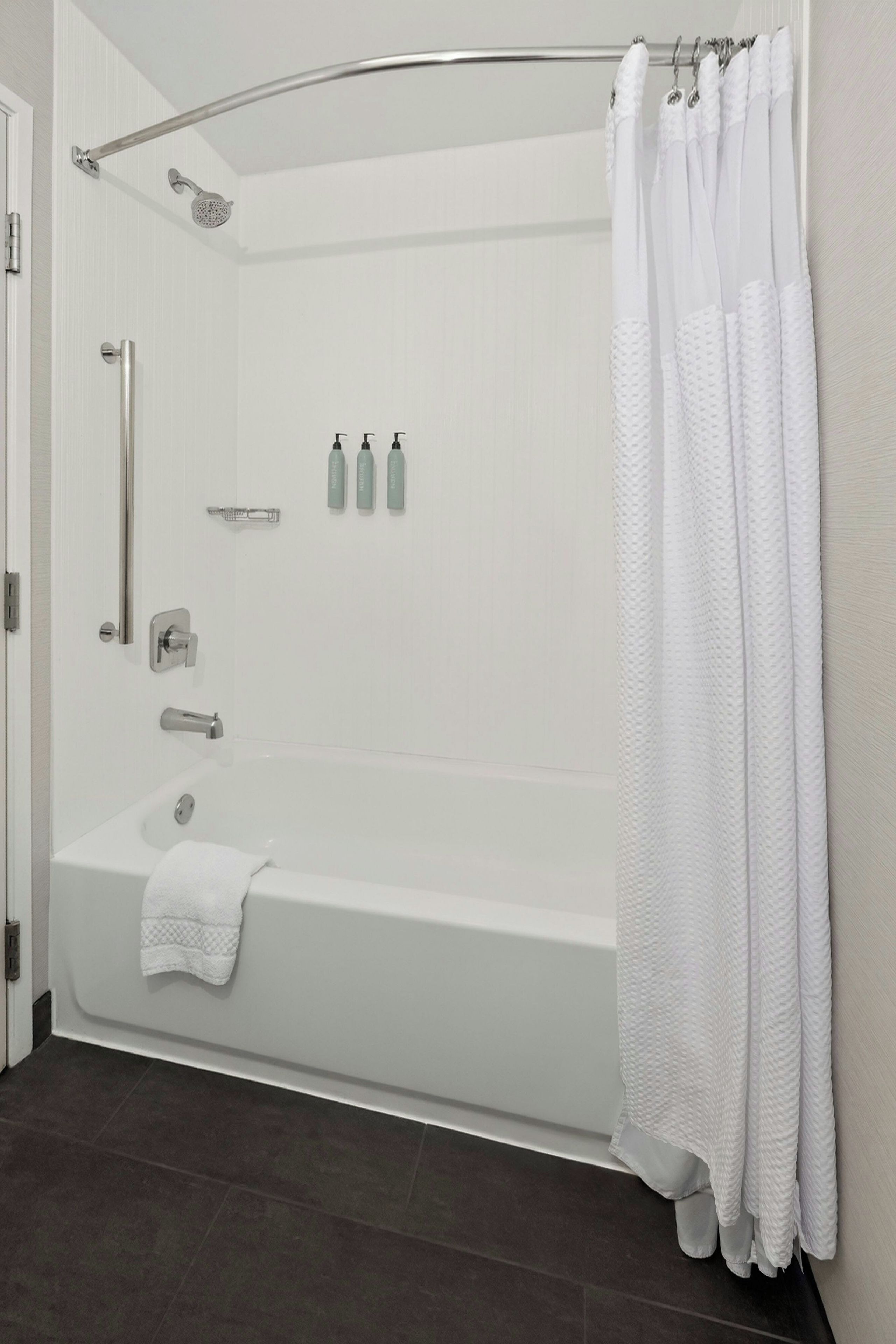 Un baño moderno con una bañera, ducha y retrete.