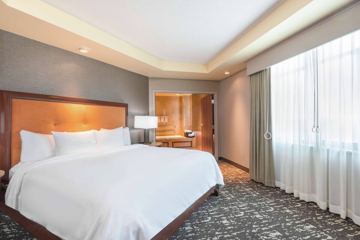Una habitación de hotel con una cama grande, un escritorio y una silla.