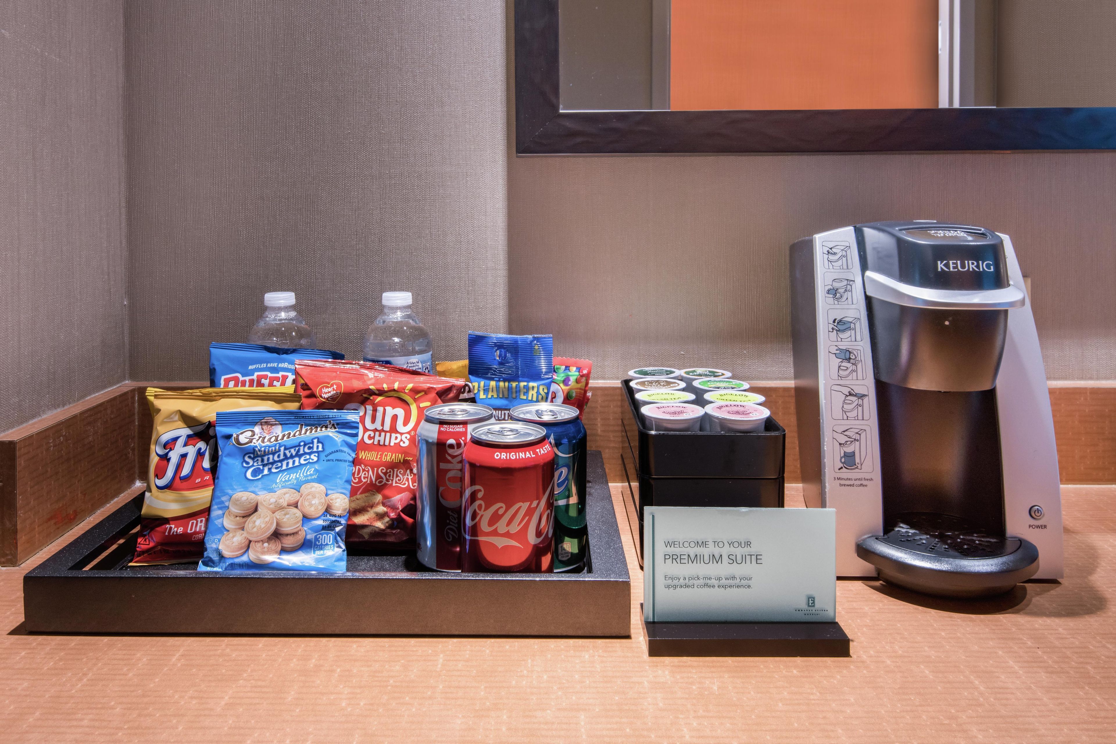 A breakfast buffet with snacks, beverages, and a Keurig coffee maker.