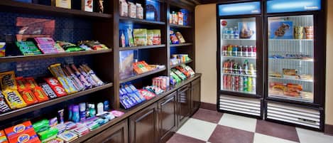 A grocery store with shelves stocked with snacks, beverages, and household items.