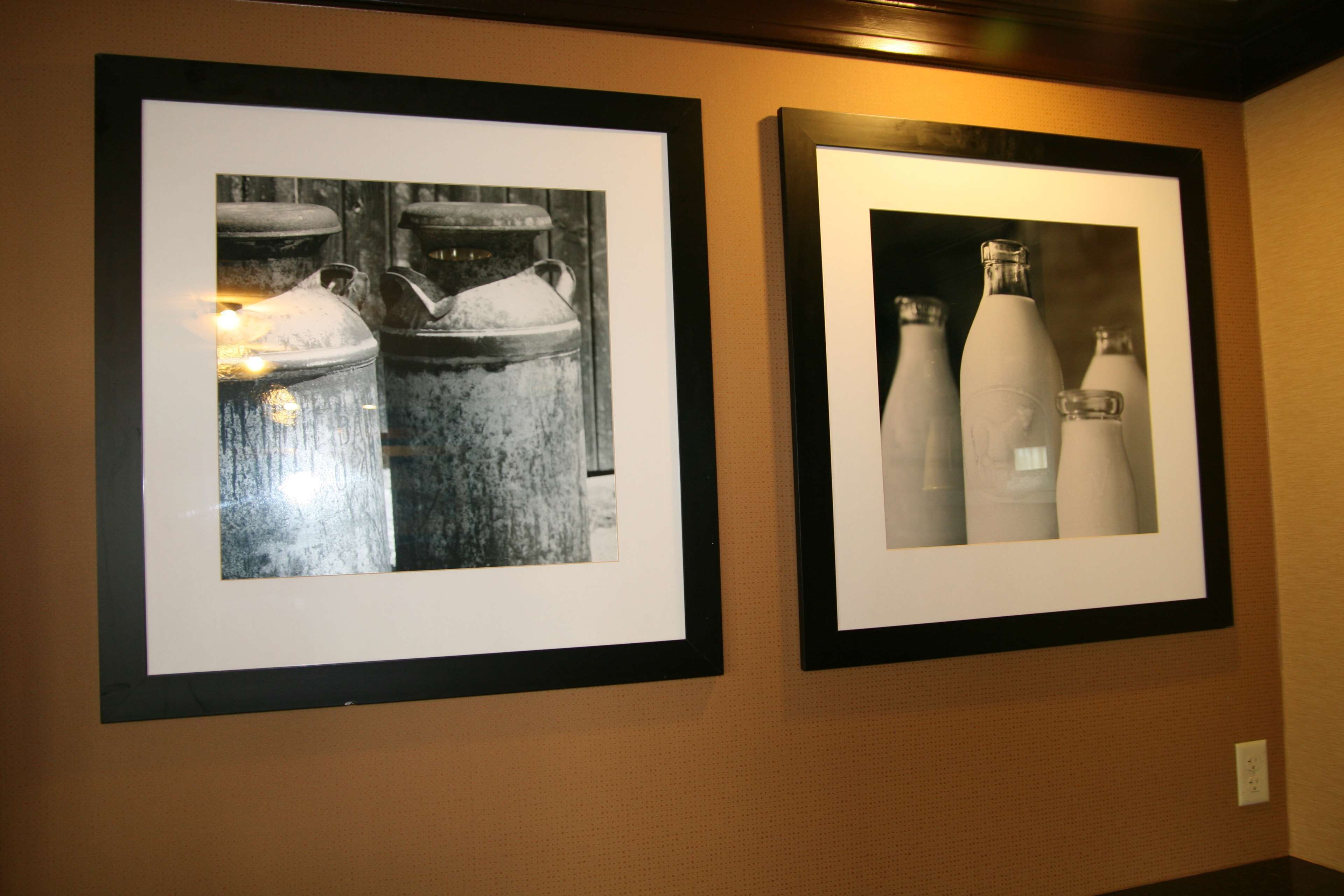 Dos fotografías en blanco y negro, enmarcadas, de objetos industriales colgadas en una pared.