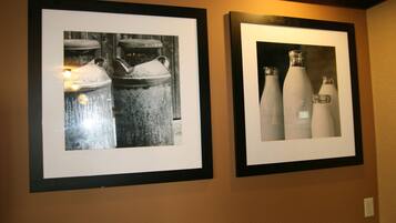 Dos fotografías en blanco y negro, enmarcadas, de objetos industriales colgadas en una pared.