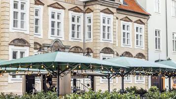 A historic building with a sign reading 'Jorgensen's Hotel' and a covered outdoor seating area with string lights.