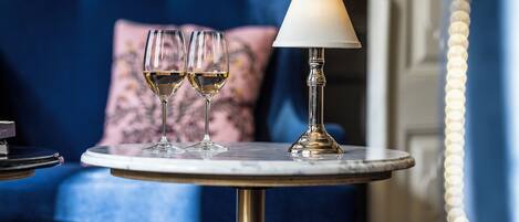 A round table with two wine glasses and a lamp.