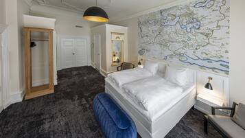 A bedroom with a large map on the wall, a bed, a wardrobe, and a bench.
