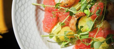 A white plate with a textured pattern, containing a dish with various ingredients.