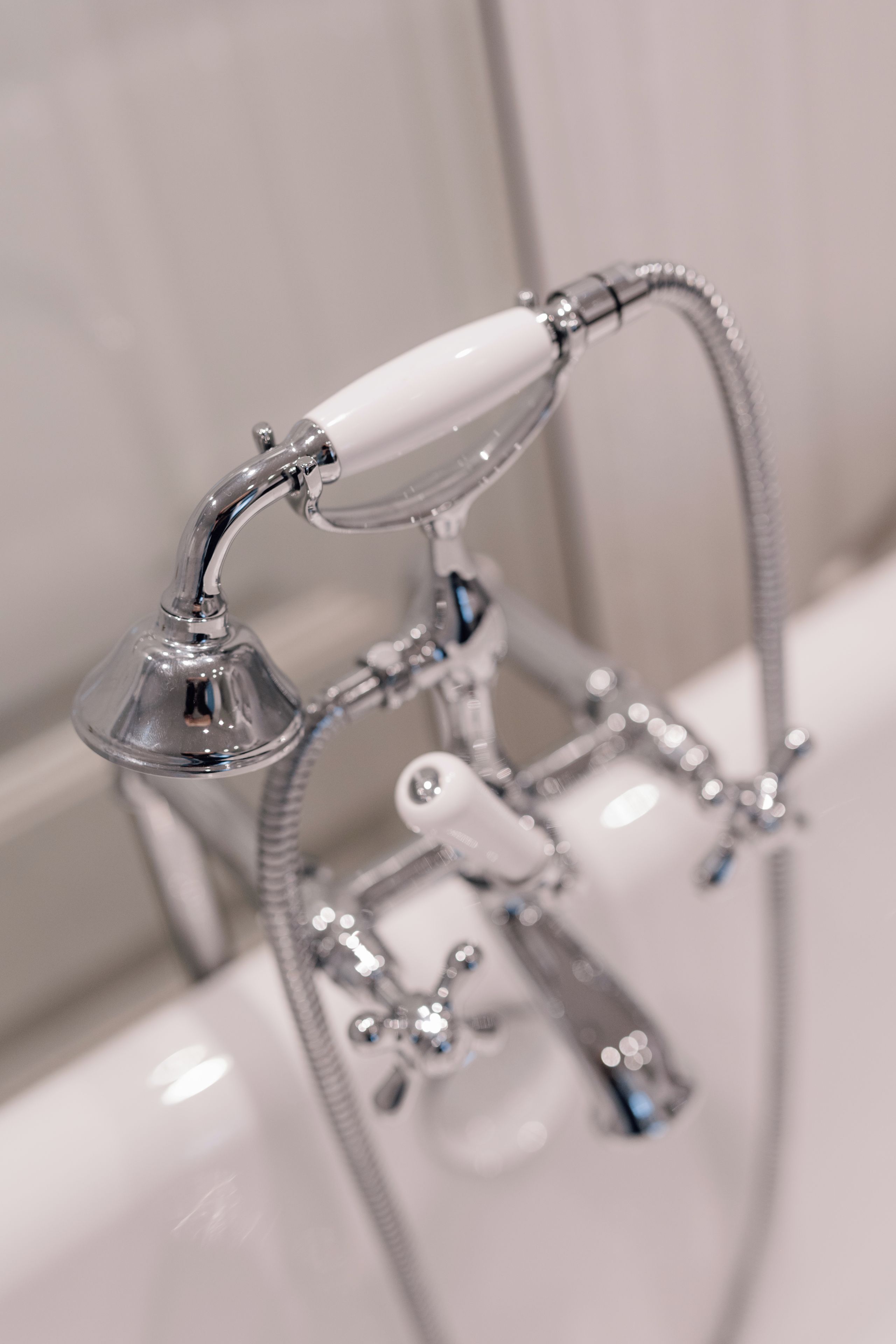 Un baño con cabezal de ducha y mandos de control.