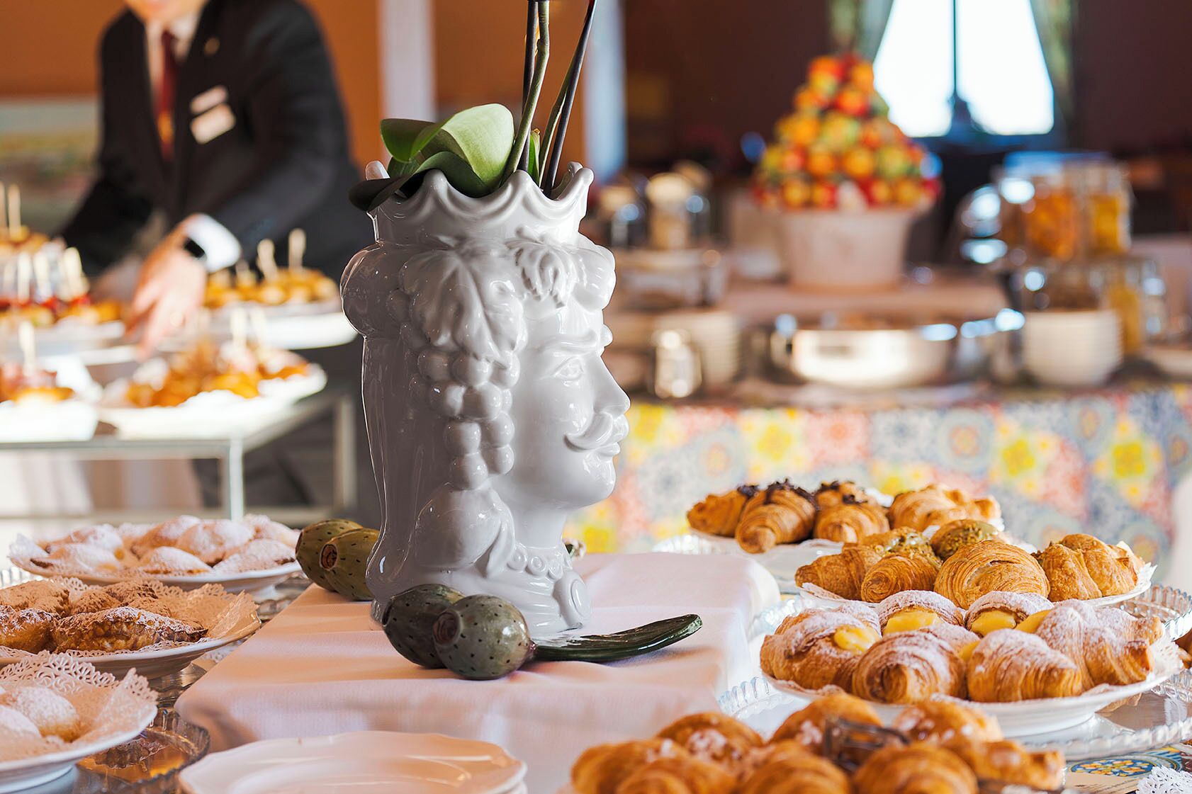 Une table de buffet garnie de diverses pâtisseries et agrémentée d’un vase décoratif.
