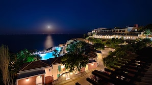 Un complejo turístico frente al mar, con piscina, edificios escalonados y vistas al océano.