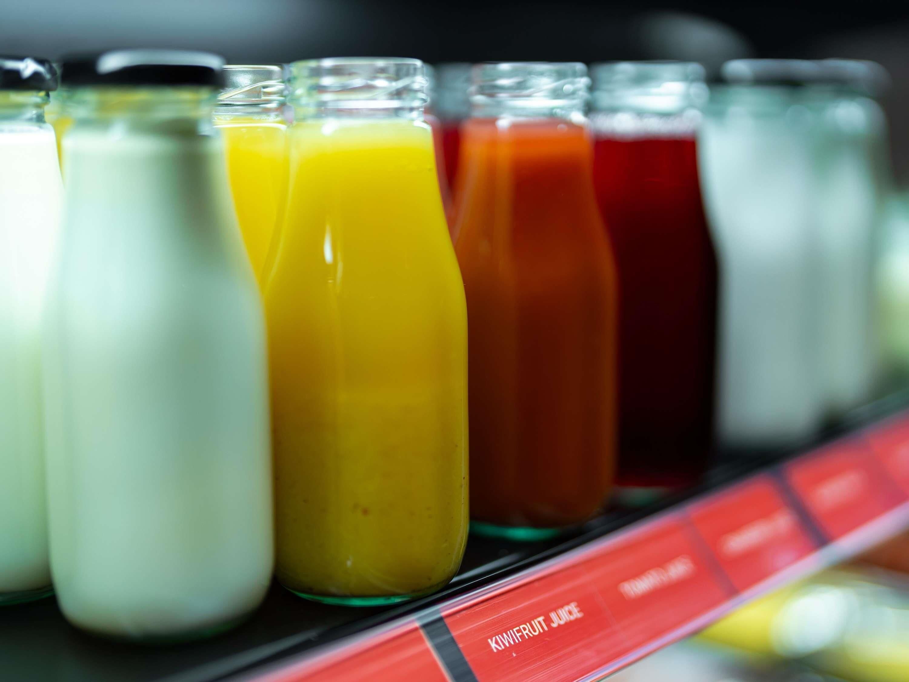 Variedad de bebidas en botellas de vidrio sobre una estantería.