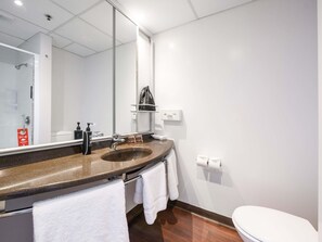A modern bathroom with a sink, mirror, and toilet.