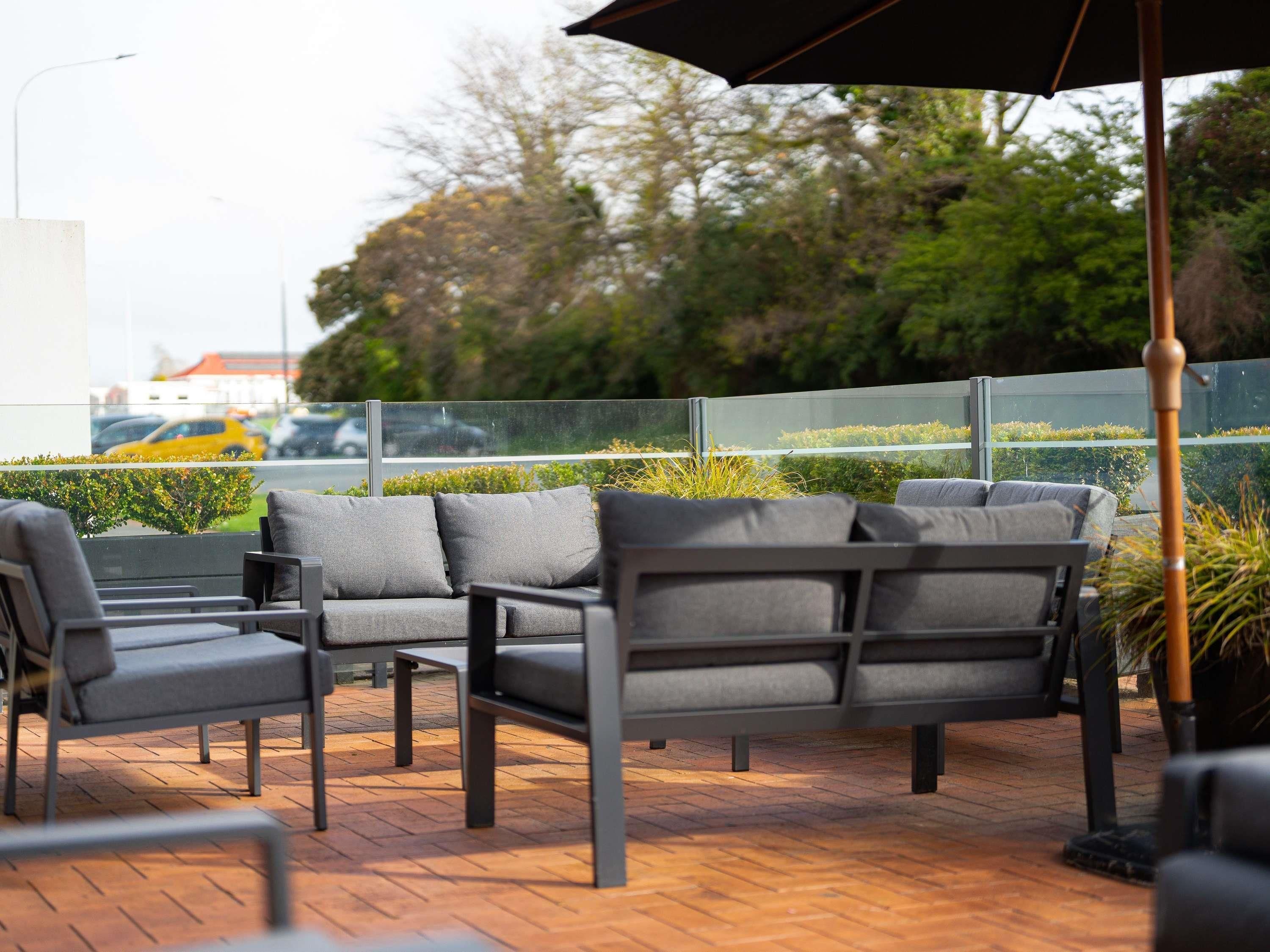 Outdoor seating with a view of the street and greenery.