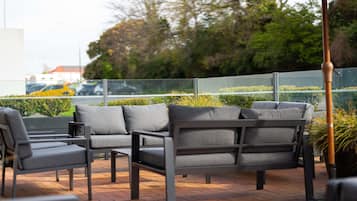 Outdoor seating with a view of the street and greenery.