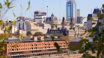 A cityscape with a mix of historic and modern buildings, including a prominent red brick building in the foreground.