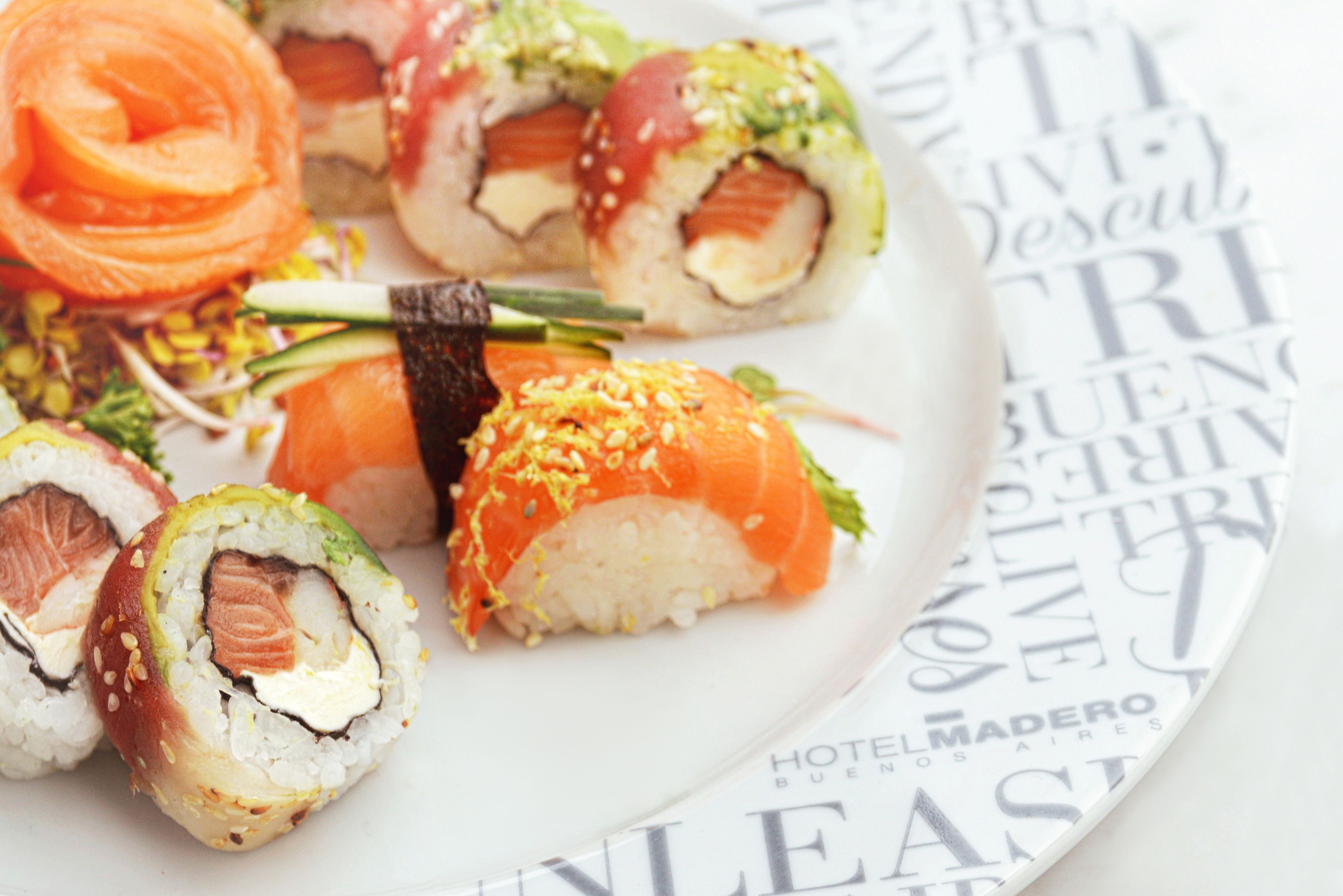 A plate of sushi with various types including salmon and avocado rolls.