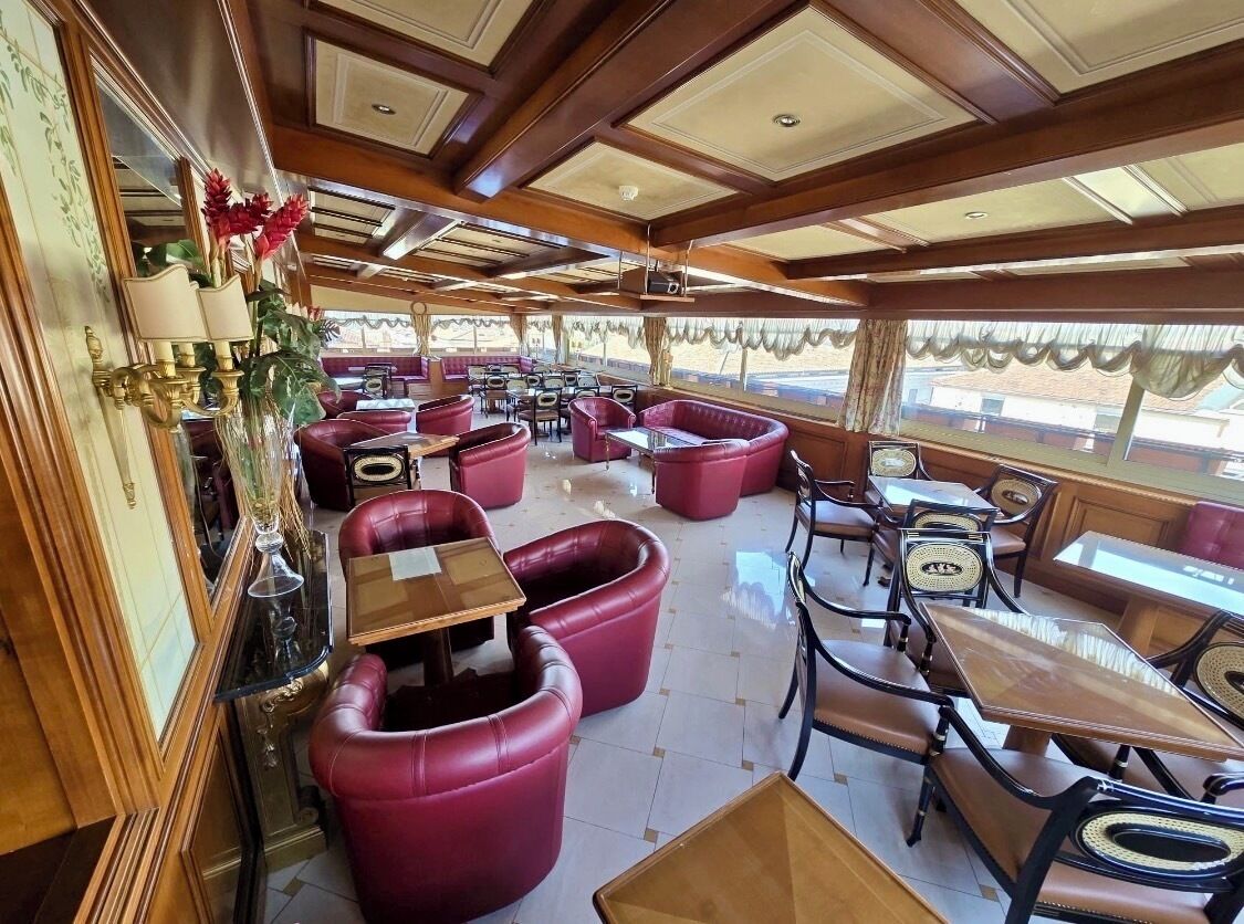 A restaurant with leather seating, wooden tables, and a classic interior design.