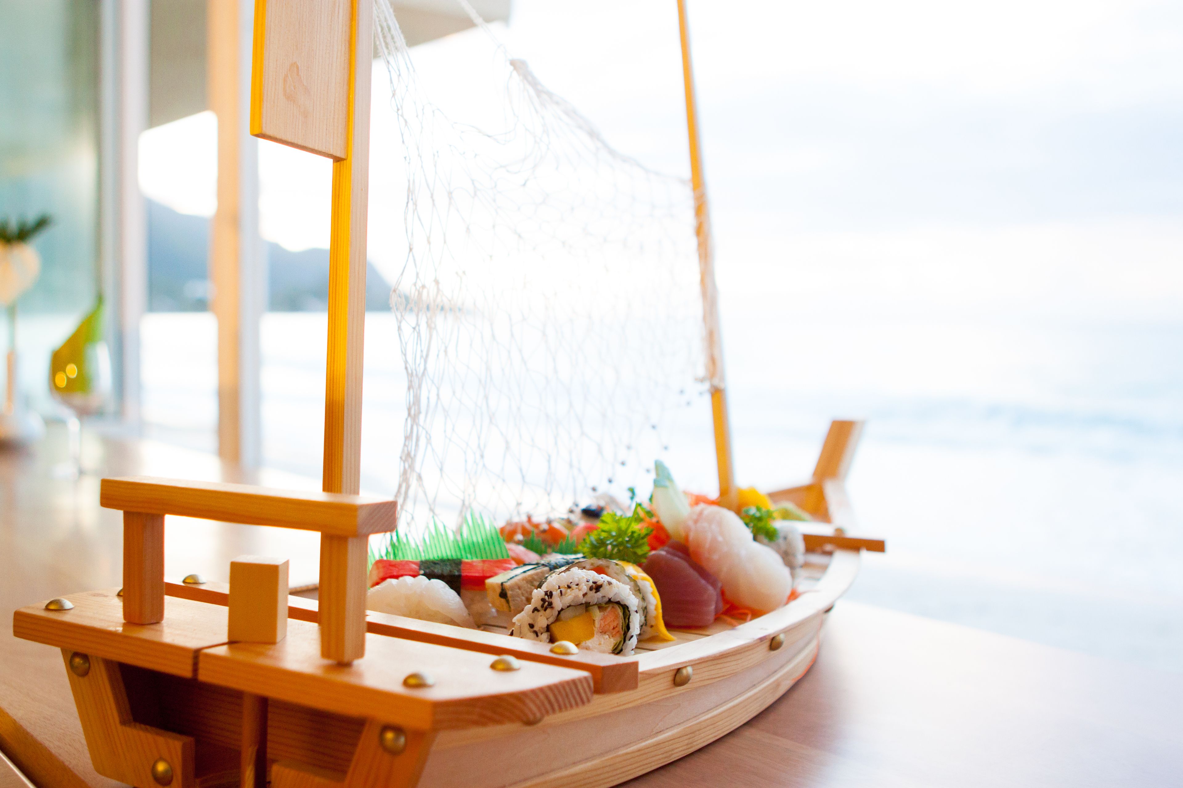 Ein hölzernes Boot mit Sushi auf einem Tisch.