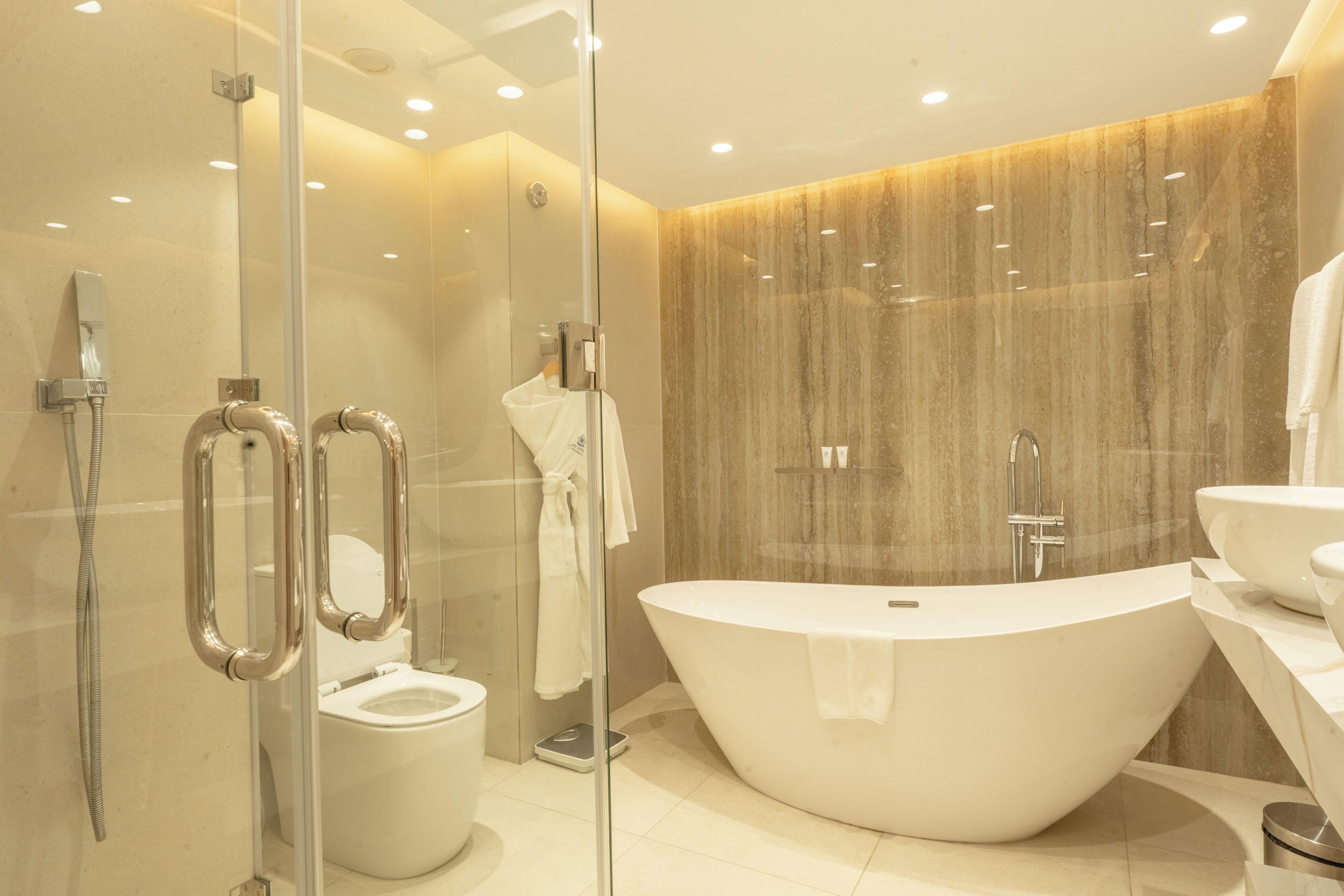 A modern bathroom with a freestanding bathtub, a glass-enclosed shower, and a toilet.
