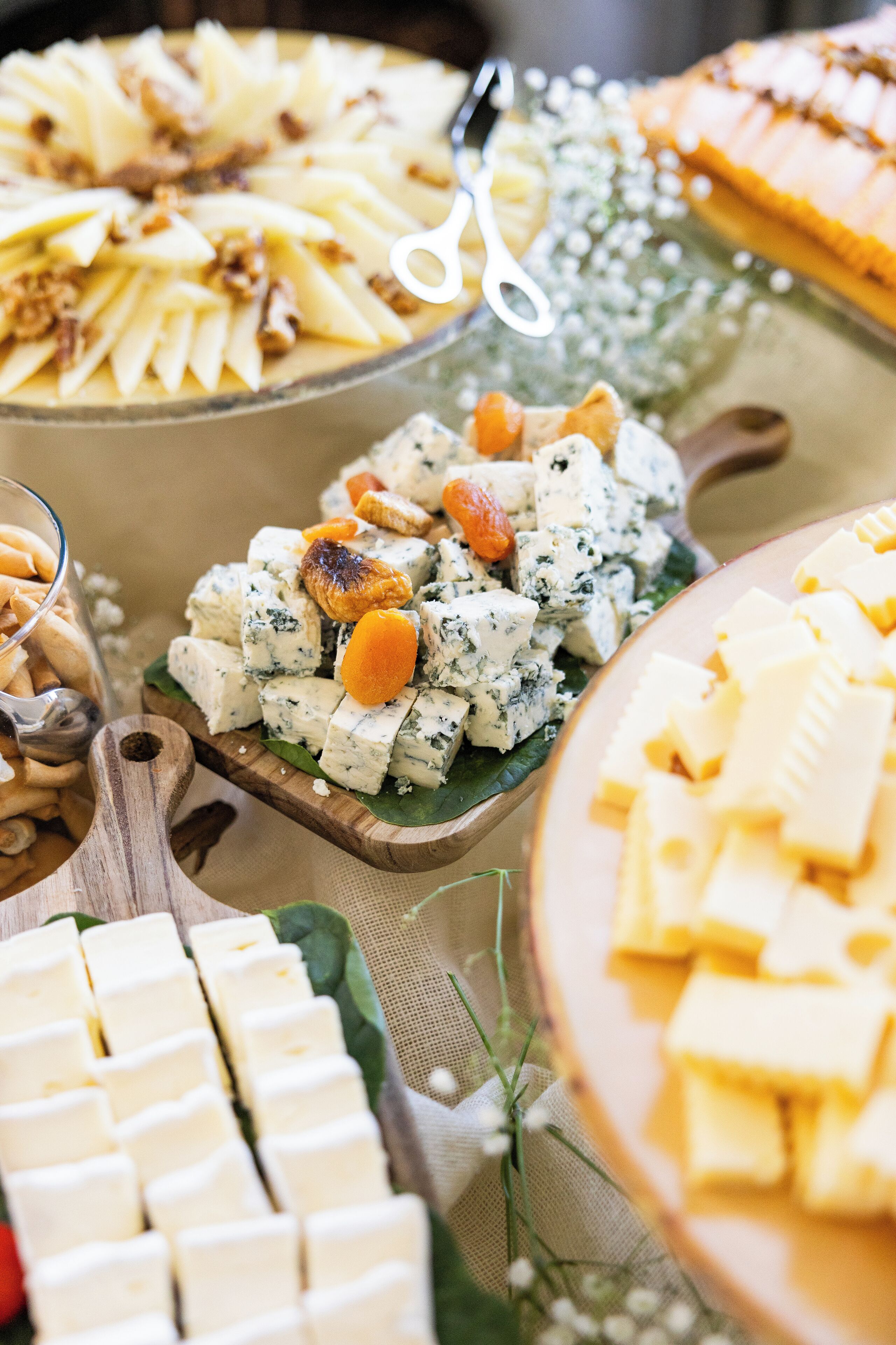 Une variété de fromages et de collations disposés sur une planche en bois.