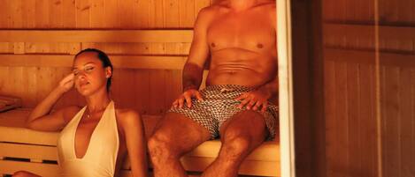 Eine Sauna mit Holzbänken und einer Glastür.