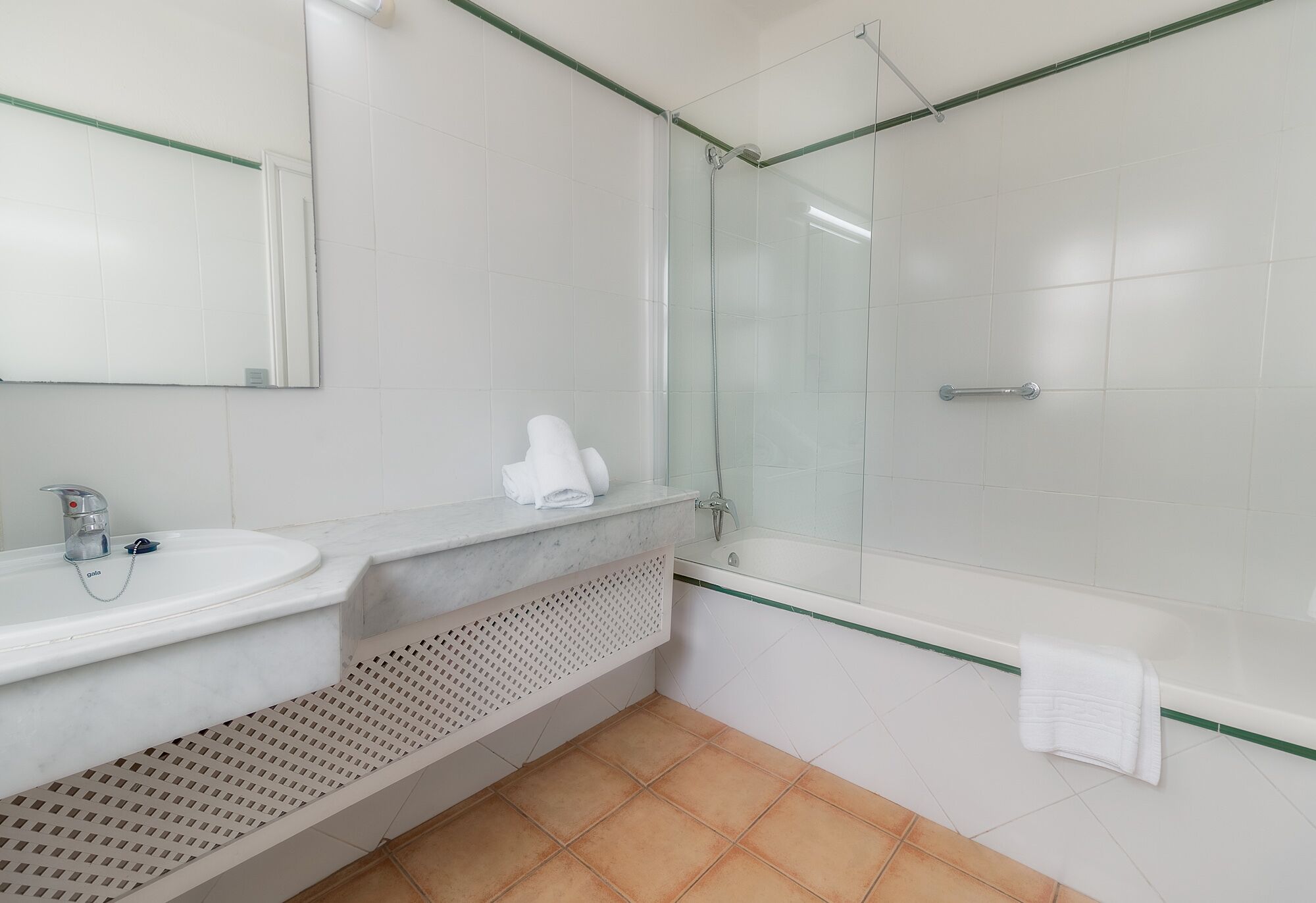 Une salle de bain moderne avec une douche à parois de verre, un lavabo blanc et un porte-serviettes.