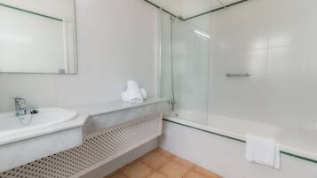 Une salle de bain moderne avec une douche à parois de verre, un lavabo blanc et un porte-serviettes.
